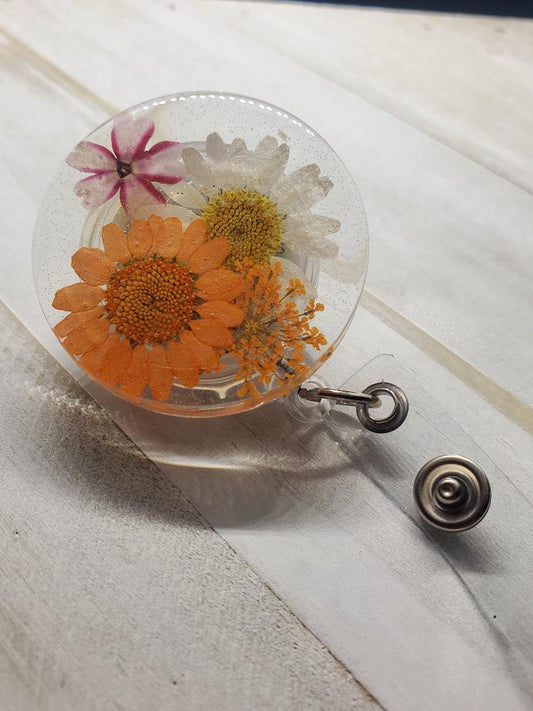 orange and white daisy badge reel